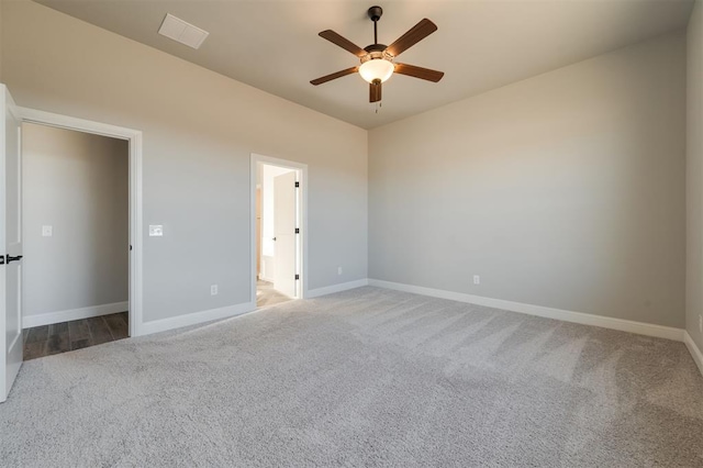 unfurnished bedroom with carpet floors, a ceiling fan, visible vents, and baseboards