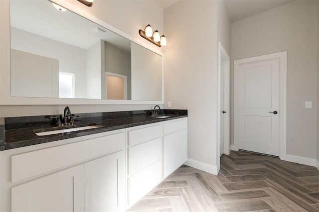 bathroom featuring visible vents, a sink, baseboards, and double vanity