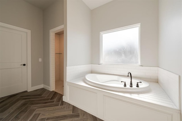 bathroom featuring a bath and parquet floors