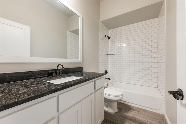 bathroom with bathing tub / shower combination, vanity, toilet, and wood finished floors