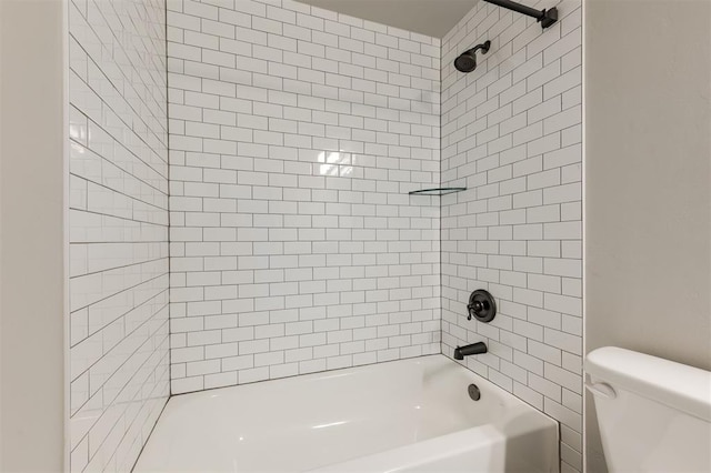 bathroom featuring toilet and tiled shower / bath combo