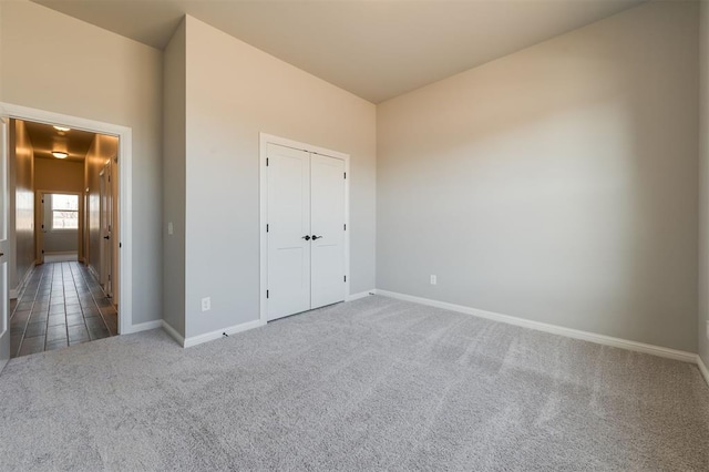 unfurnished bedroom with dark carpet and a closet