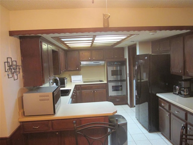 kitchen with black refrigerator, light tile patterned floors, double oven, stovetop, and kitchen peninsula