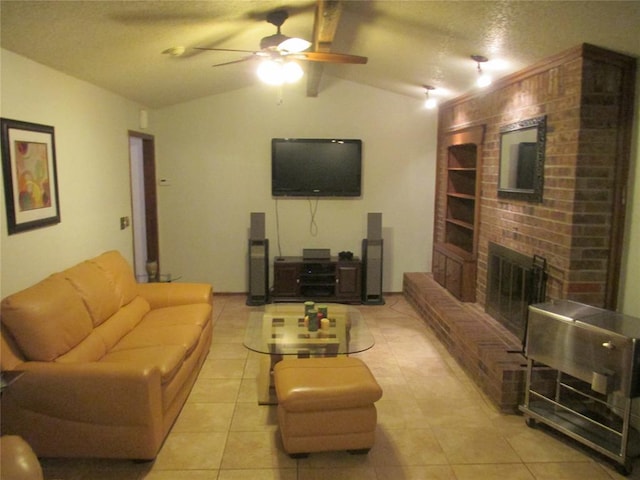 tiled living room with a textured ceiling, vaulted ceiling with beams, a brick fireplace, and ceiling fan