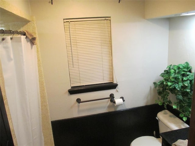 bathroom featuring curtained shower and toilet