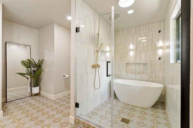 bathroom with tile patterned flooring, tile walls, and separate shower and tub