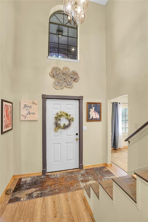 entryway with wood-type flooring and a chandelier