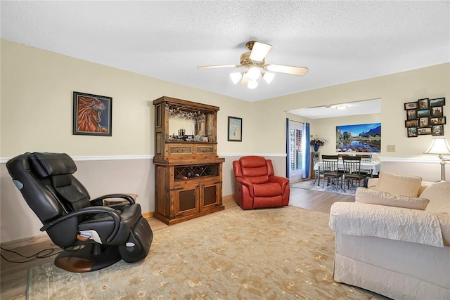 living room with a textured ceiling and ceiling fan