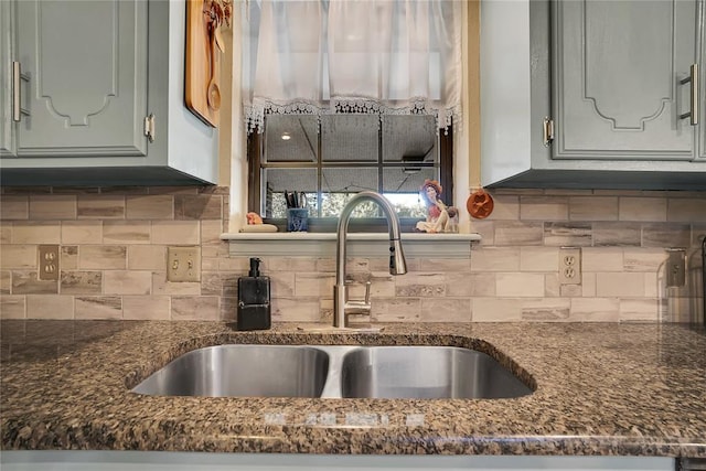 kitchen with tasteful backsplash, sink, and dark stone counters