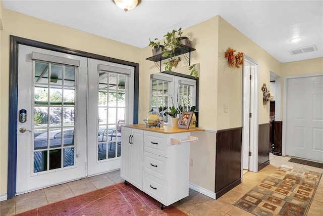 doorway to outside with french doors and light tile patterned floors