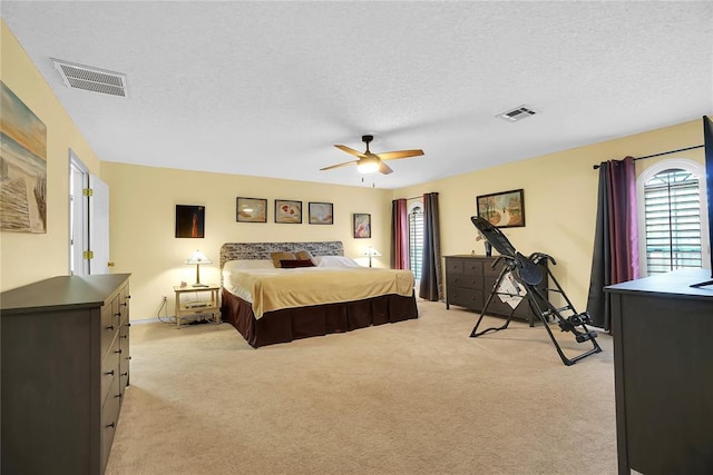 carpeted bedroom with a textured ceiling and ceiling fan