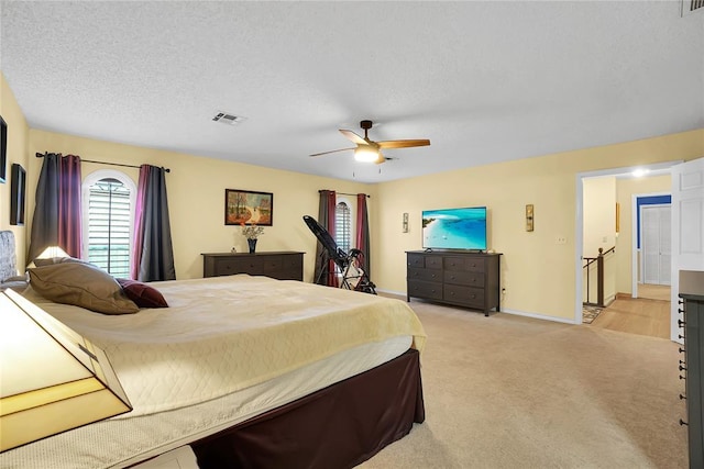 carpeted bedroom featuring ceiling fan and a textured ceiling