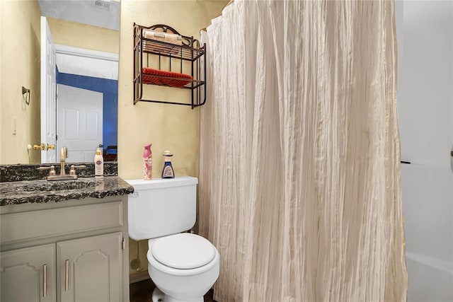 bathroom featuring vanity, curtained shower, and toilet