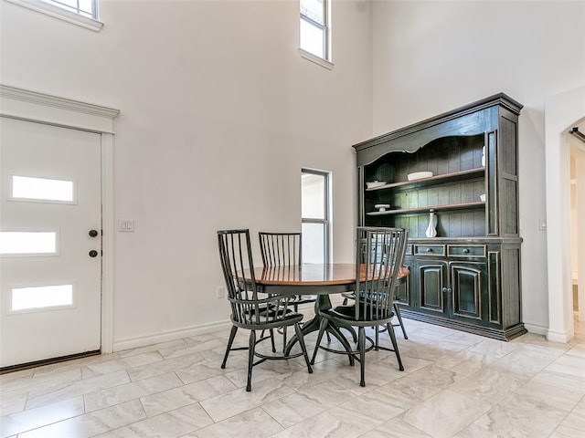 dining room with a towering ceiling