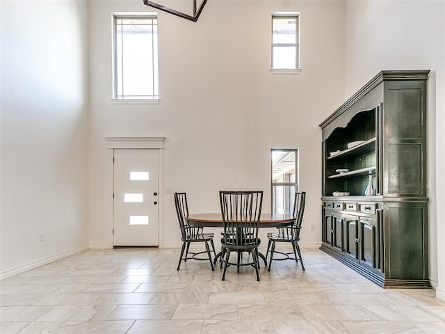 dining space with a towering ceiling and plenty of natural light