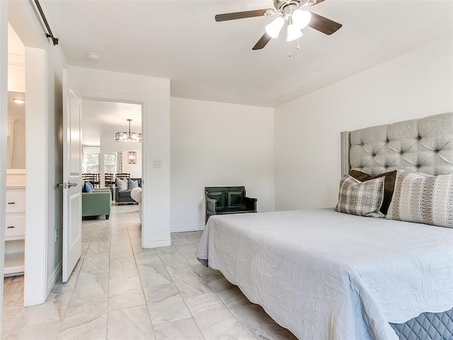 bedroom featuring ceiling fan with notable chandelier and a barn door