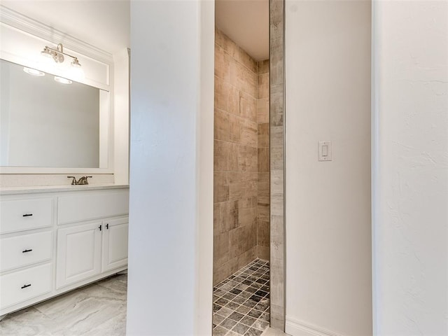 bathroom featuring vanity and tiled shower