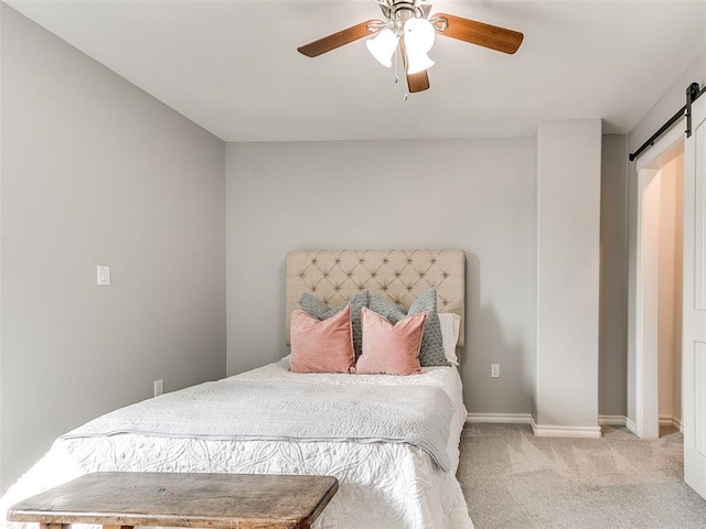 bedroom featuring light carpet, a barn door, and ceiling fan