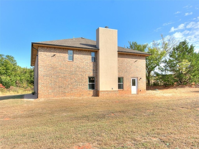 rear view of house featuring a yard