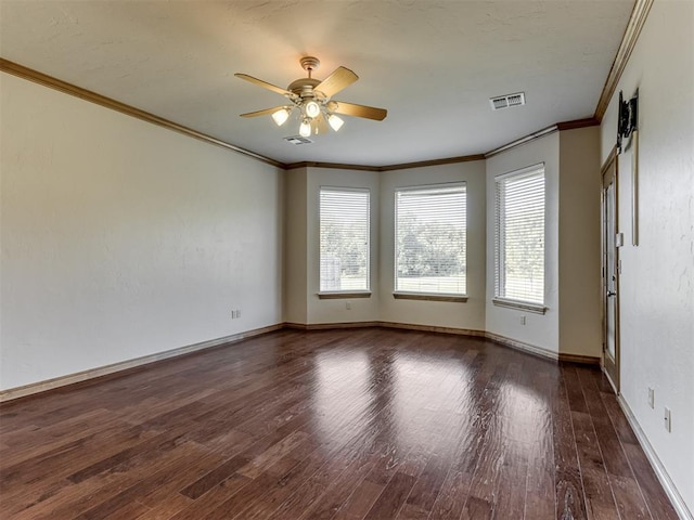 empty room with ceiling fan, dark hardwood / wood-style flooring, and ornamental molding