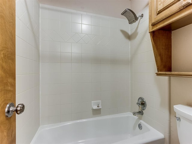 bathroom featuring toilet and tiled shower / bath