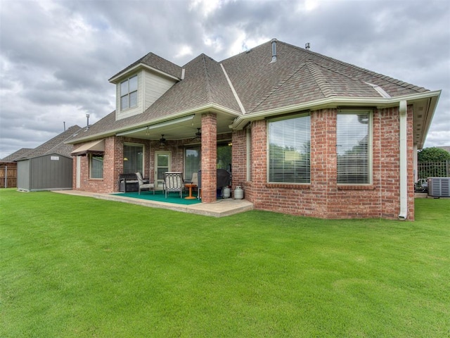 back of house with a lawn, cooling unit, ceiling fan, a shed, and a patio area