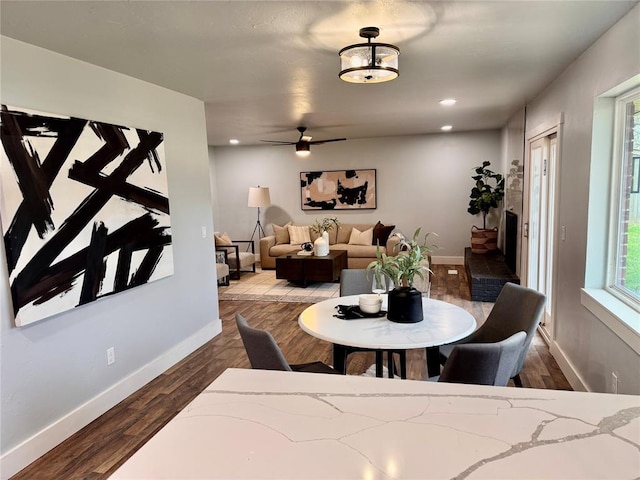 dining room with ceiling fan and dark wood-type flooring