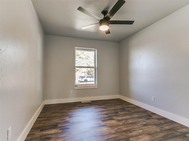 spare room featuring ceiling fan and dark wood-type flooring