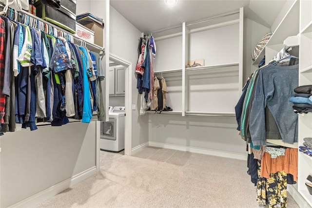 spacious closet featuring washer / clothes dryer and light colored carpet