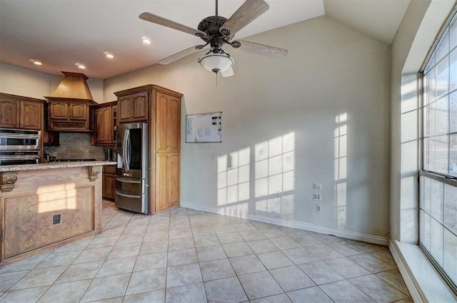 kitchen with lofted ceiling, decorative backsplash, light tile patterned floors, ceiling fan, and stainless steel appliances