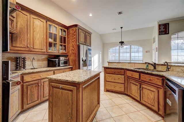 kitchen with sink, light tile patterned floors, ceiling fan, stainless steel appliances, and a kitchen island