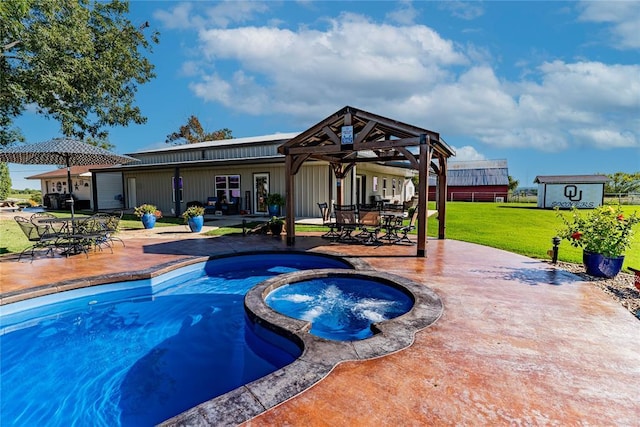 view of swimming pool featuring a lawn, a patio area, an in ground hot tub, and a shed