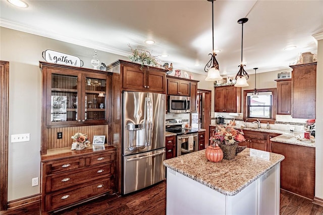 kitchen featuring pendant lighting, a center island, dark hardwood / wood-style floors, light stone counters, and stainless steel appliances