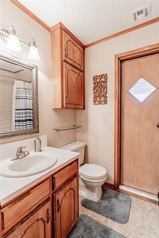 bathroom featuring vanity, toilet, walk in shower, and crown molding