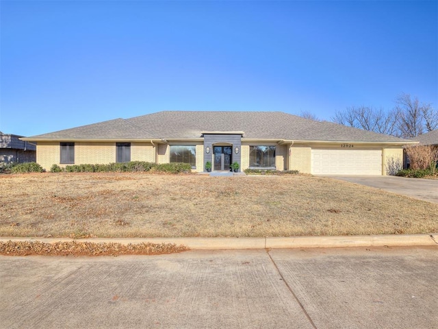 ranch-style home with driveway, a shingled roof, and a garage