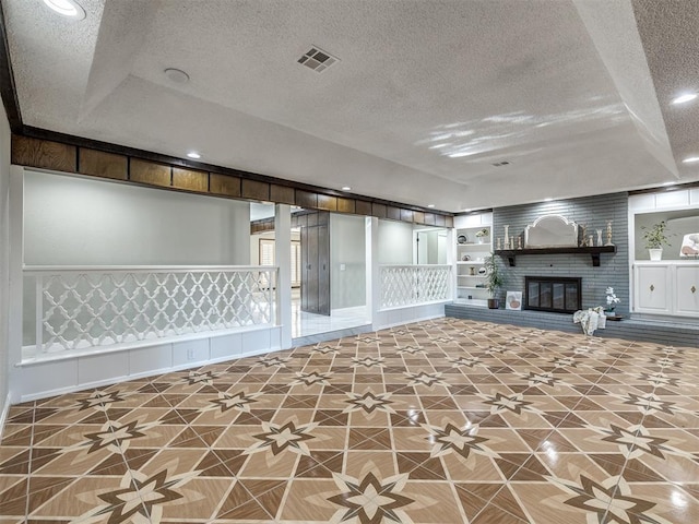 interior space featuring tile patterned floors, a fireplace, built in features, and a textured ceiling