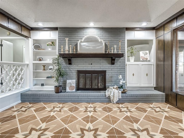 unfurnished living room featuring a fireplace, built in features, and a textured ceiling