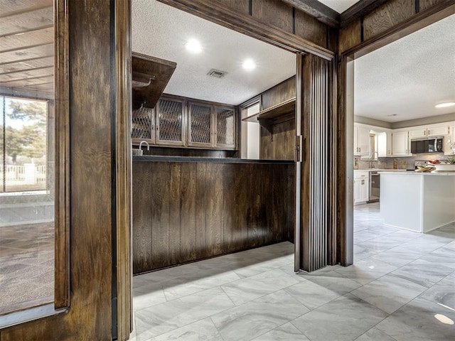 kitchen with tasteful backsplash, visible vents, appliances with stainless steel finishes, a textured ceiling, and white cabinetry