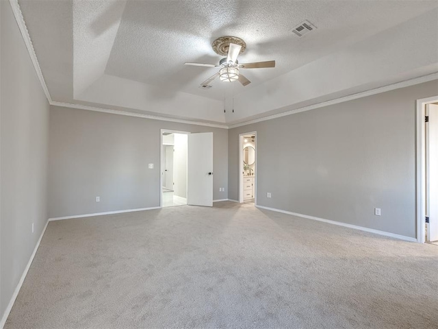 unfurnished room with a textured ceiling, a tray ceiling, ceiling fan, and ornamental molding