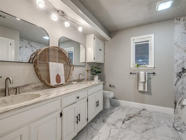 full bathroom featuring a textured ceiling, double vanity, marble finish floor, and a sink