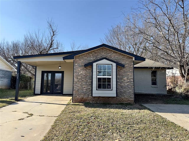 view of front of property featuring a front yard and french doors