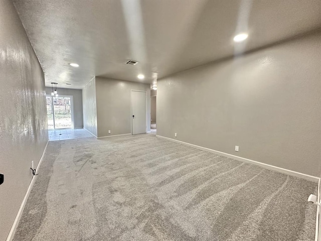 unfurnished room with carpet flooring and an inviting chandelier