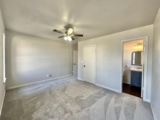 unfurnished bedroom with sink, carpet flooring, ceiling fan, connected bathroom, and a closet