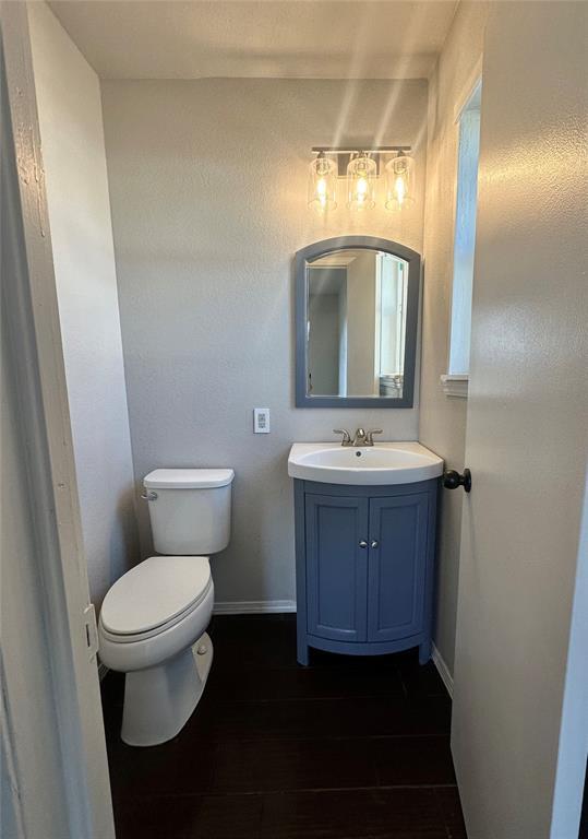 bathroom with hardwood / wood-style flooring, vanity, and toilet