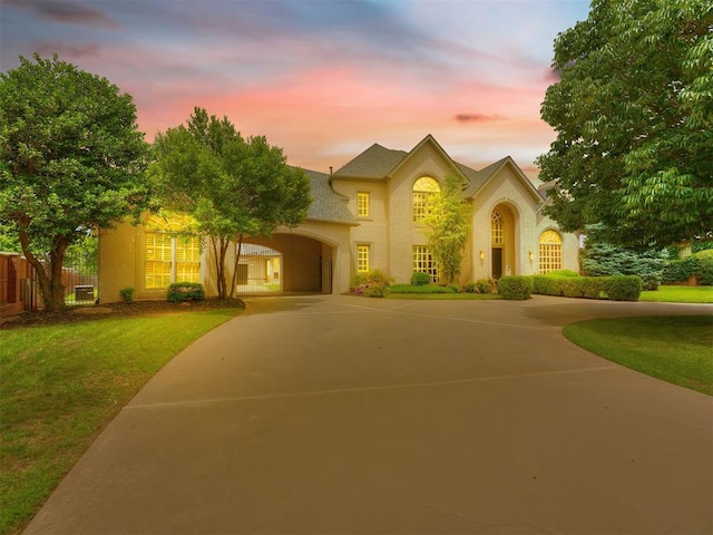 view of front of house featuring fence, concrete driveway, and a yard