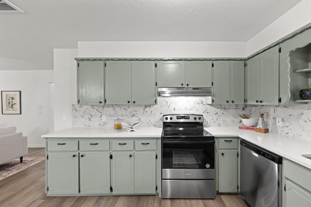 kitchen with stainless steel appliances, light hardwood / wood-style flooring, and tasteful backsplash