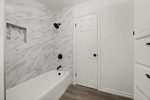 bathroom with hardwood / wood-style flooring and tiled shower / bath combo