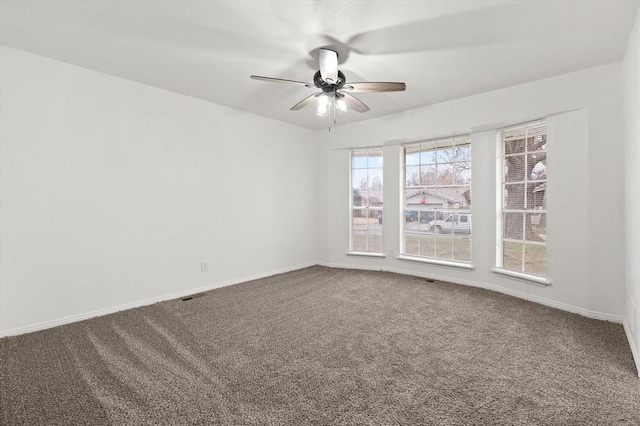 carpeted spare room with ceiling fan and a healthy amount of sunlight