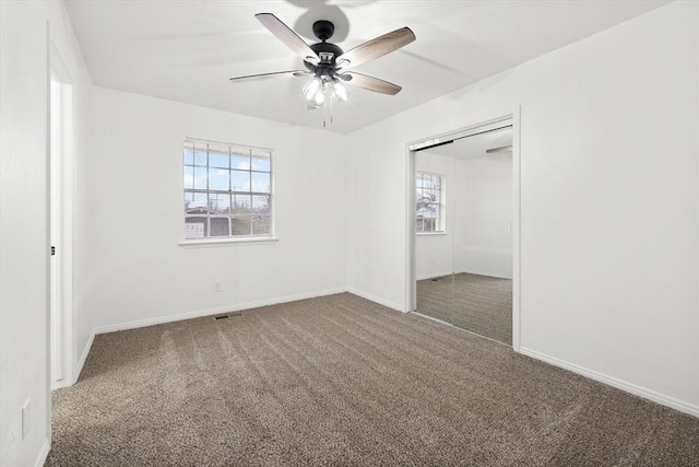 unfurnished bedroom with ceiling fan, a closet, and carpet flooring