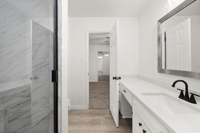 bathroom with hardwood / wood-style floors, walk in shower, and vanity